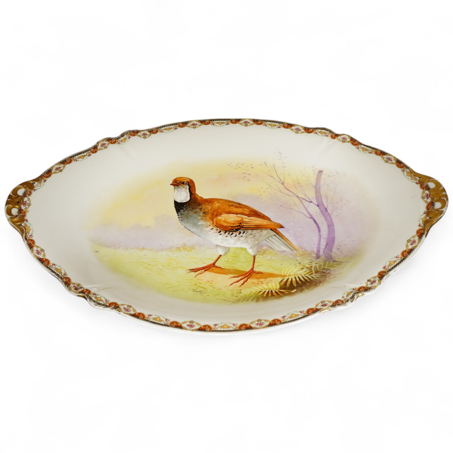 A Limoges oval porcelain serving dish hand painted with a French Red Legged Partridge signed Lattel, width 51cm